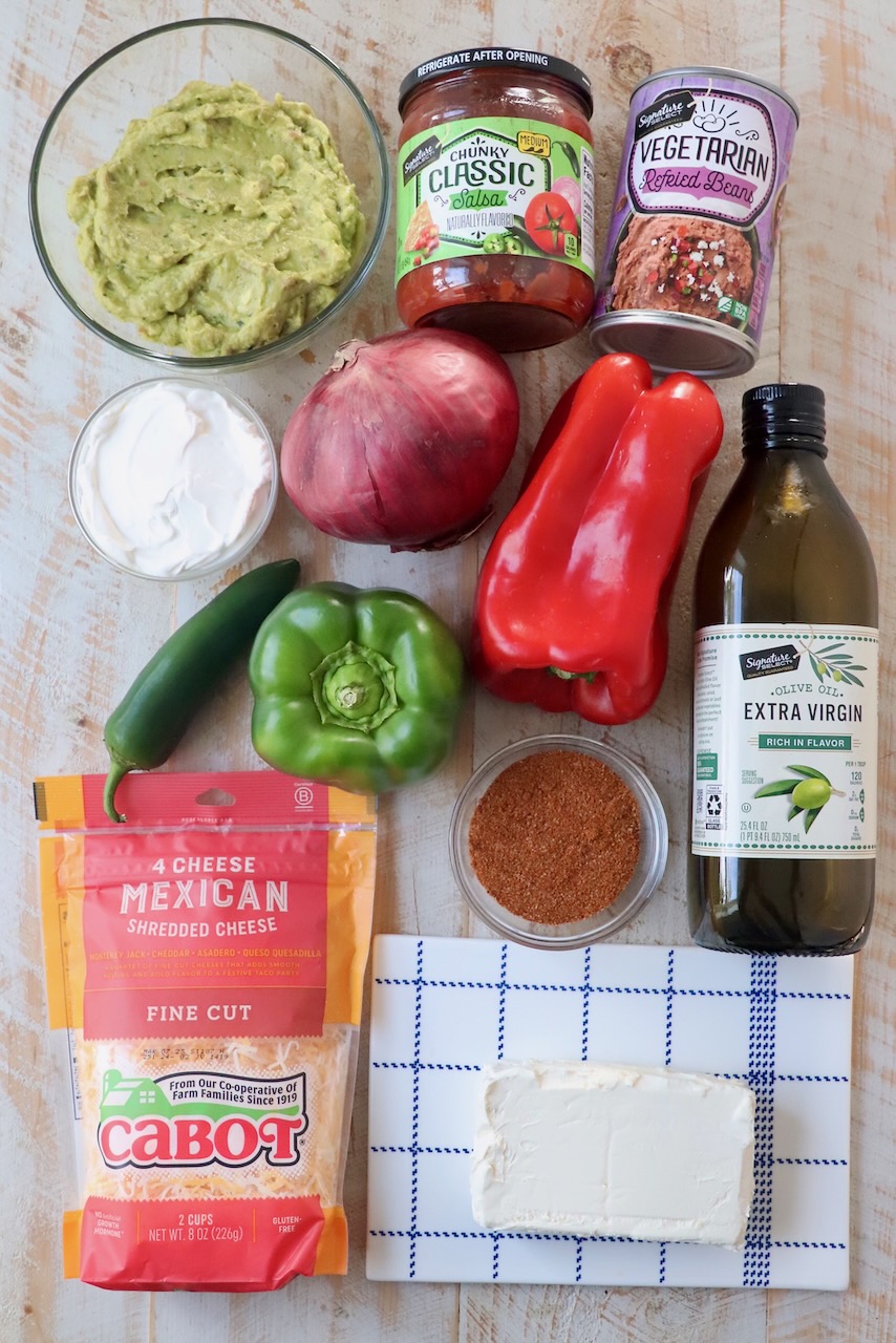 ingredients for seven layer dip on wood board
