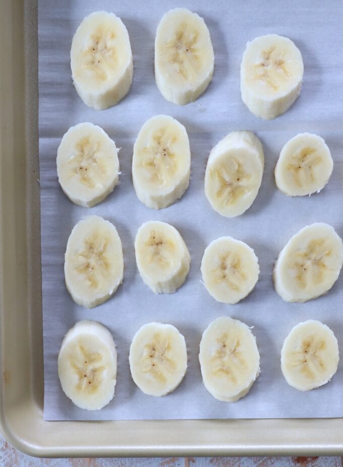 banana slices on parchment lined baking sheet