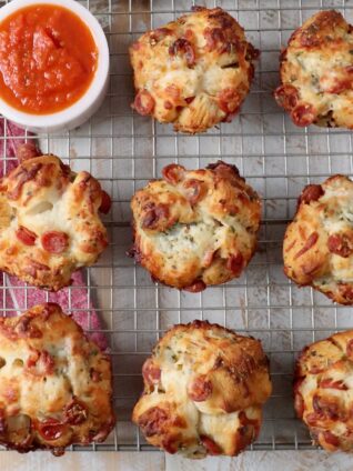 pull apart pizza rolls on wire rack with bowl of marinara sauce