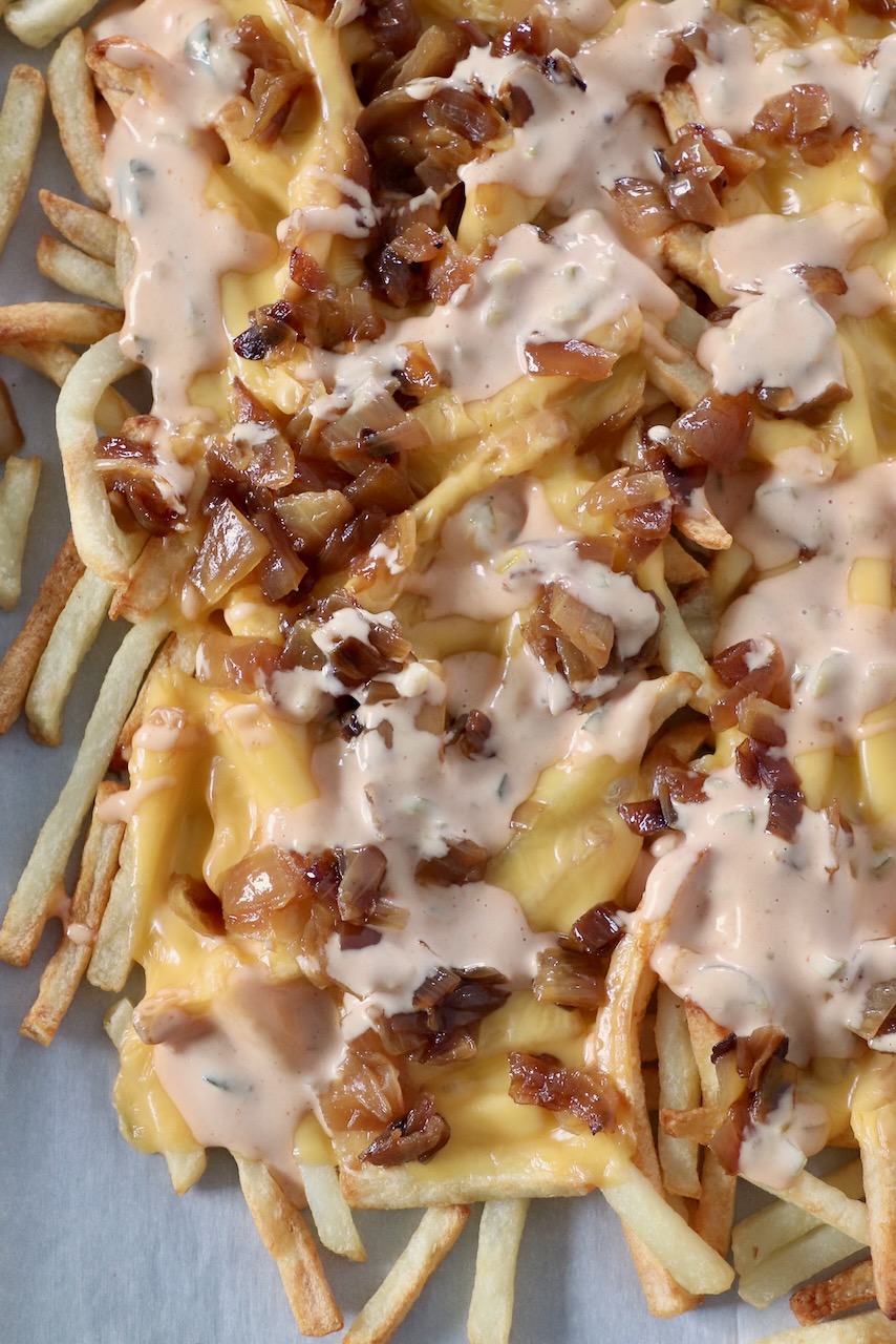 animal style fries on parchment lined baking sheet