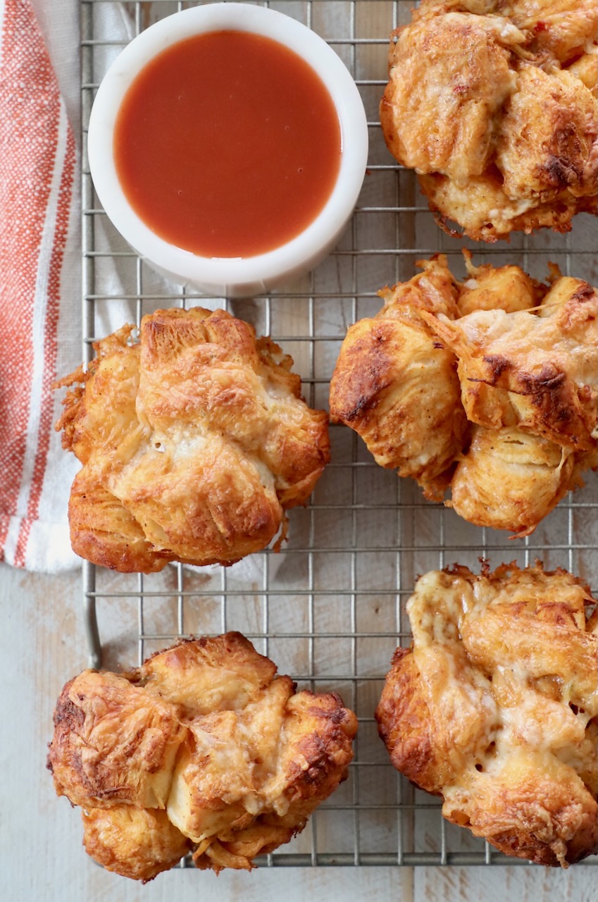 pull apart rolls on wire rack with small bowl of buffalo sauce on the side