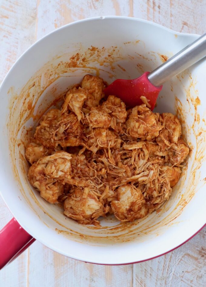 buffalo chicken roll ingredients tossed together in mixing bowl