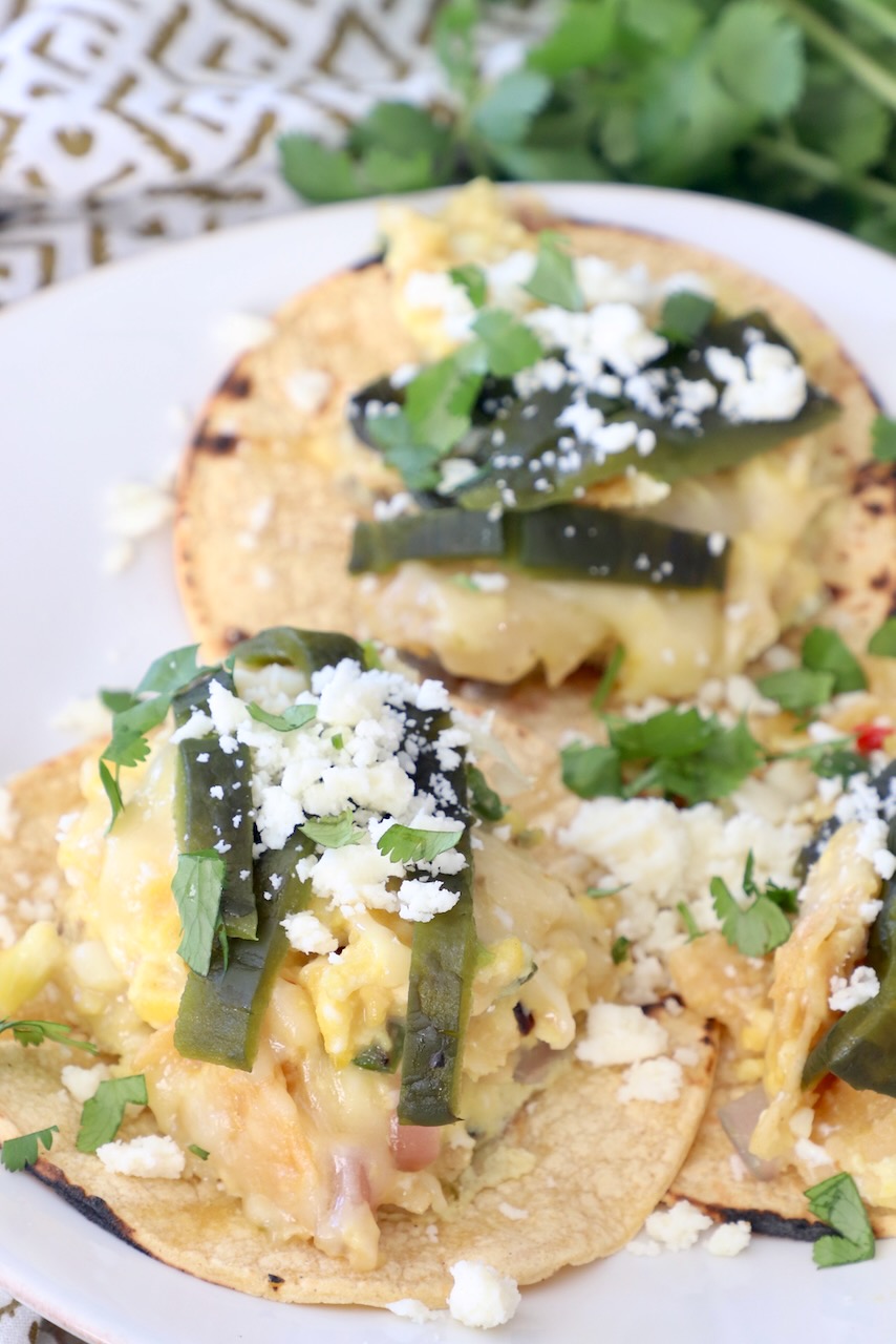 migas tacos on plate topped with roasted poblano peppers