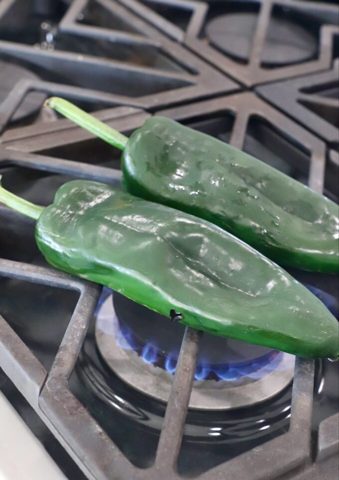 raw poblano peppers on gas stovetop