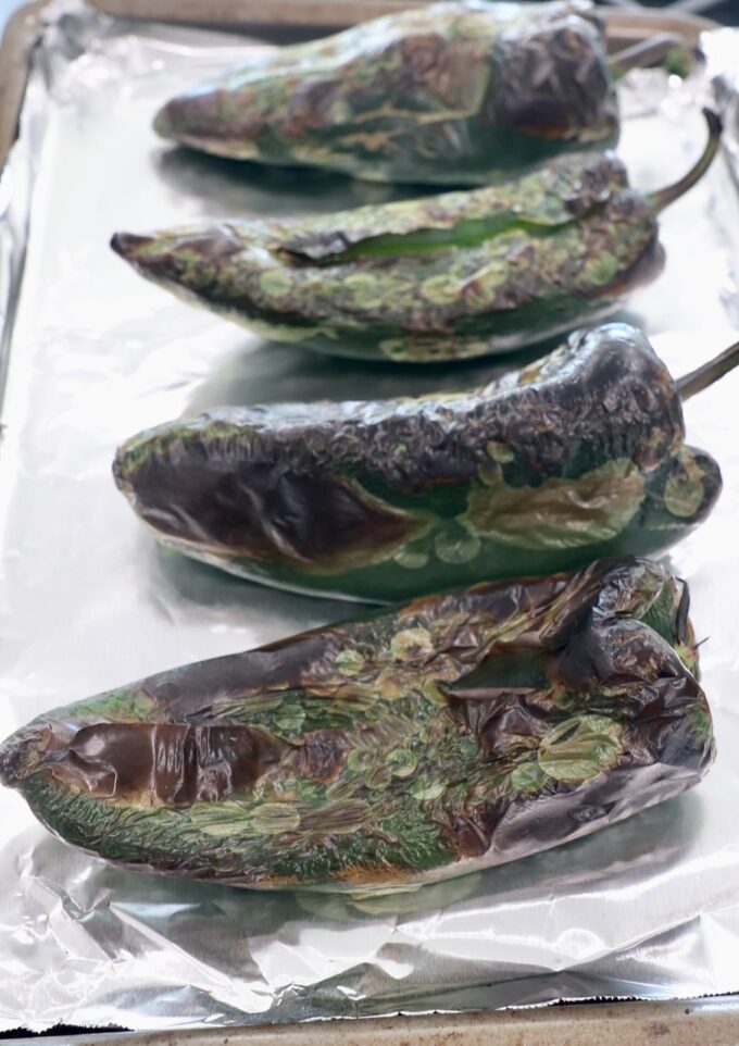 roasted poblano peppers on foil lined baking sheet