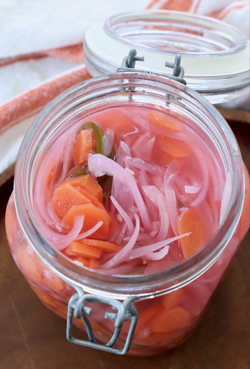 pickled vegetables in large glass jar with the lid open