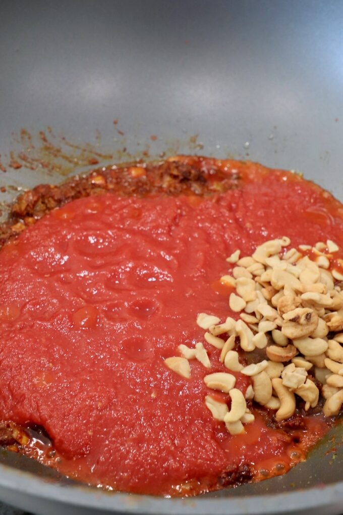 crushed tomatoes in large skillet with cashews