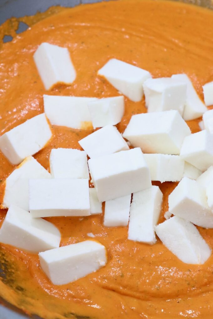 cubes of paneer in pan with curry sauce