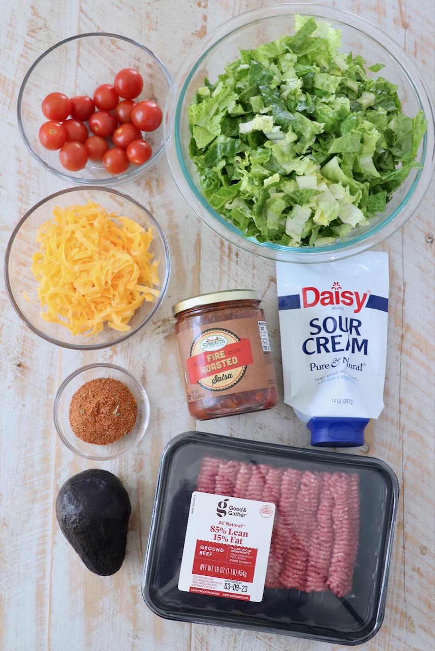 ingredients for taco salad on white wood board