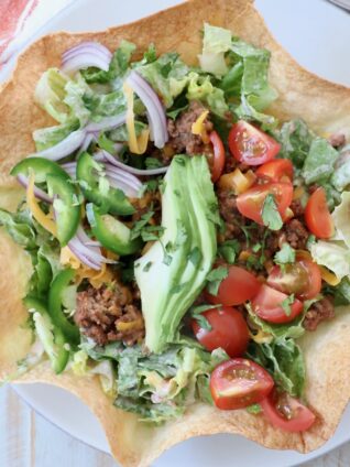 taco salad in tortilla shell on plate