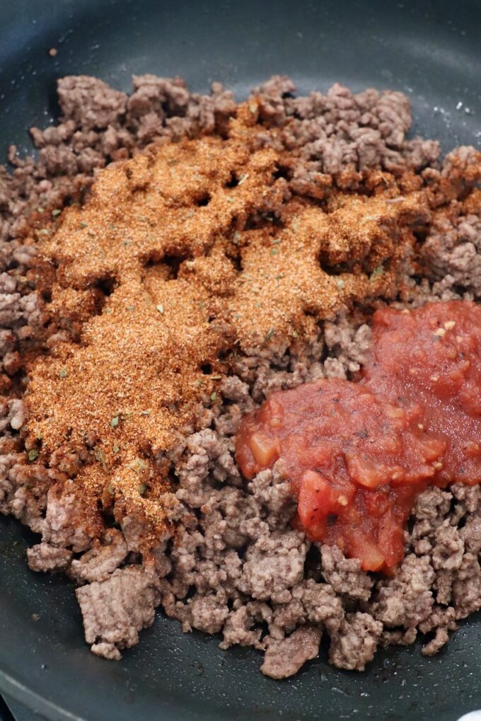 cooked ground beef in skillet with taco seasoning and salsa