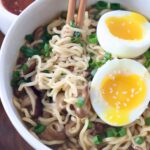 cooked ramen noodles in bowl with chopsticks and soft boiled egg