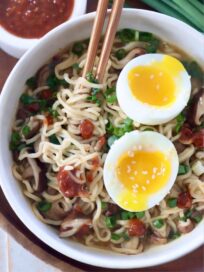 prepared ramen noodle soup in bowl with soft boiled egg on top