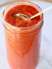 red enchilada sauce in mason jar with spoon