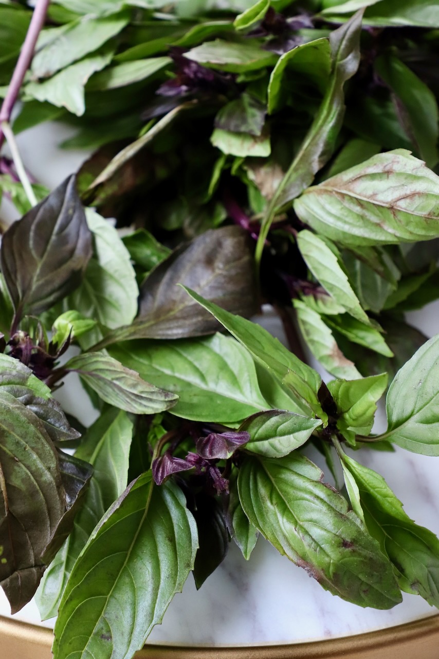 fresh thai basil leaves on marble tray