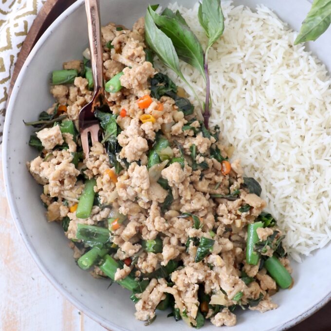 cooked ground chicken with thai basil and green beans in bowl with cooked white rice