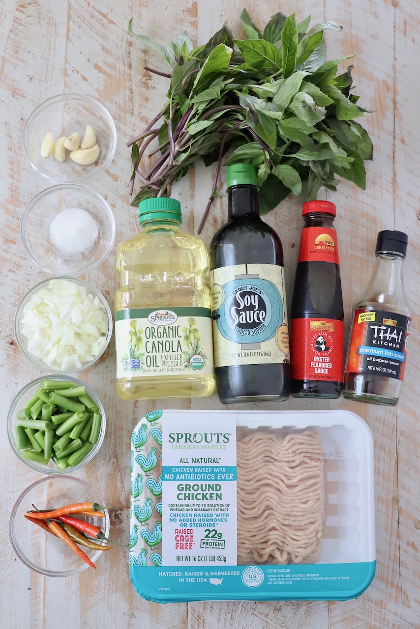 ingredients for thai basil chicken on white wood board