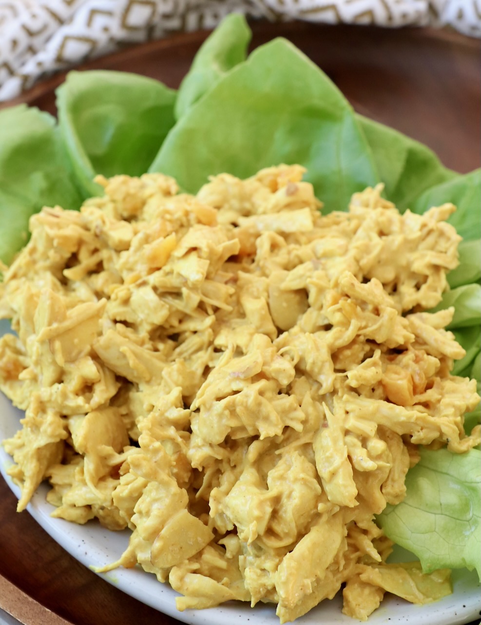 curry chicken salad on top of lettuce leaves on plate