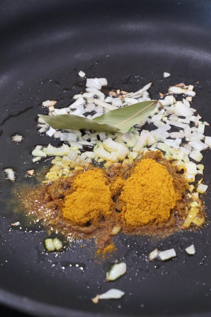 curry powder, diced shallots and bay leaf in a skilelt