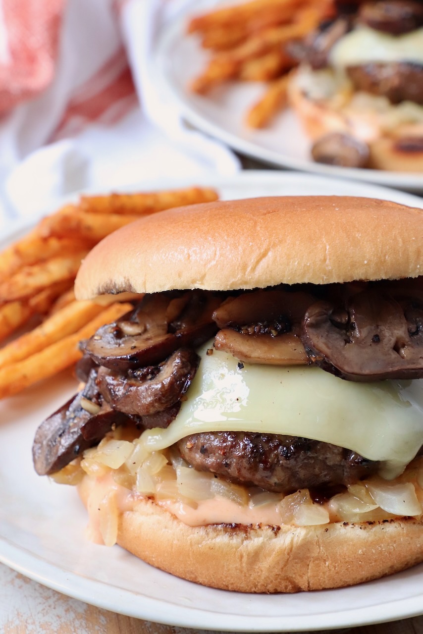 mushroom swiss burger on plate with seasoned fries