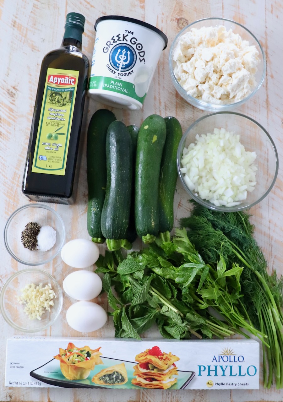 ingredients for Greek zucchini pie on white wood board