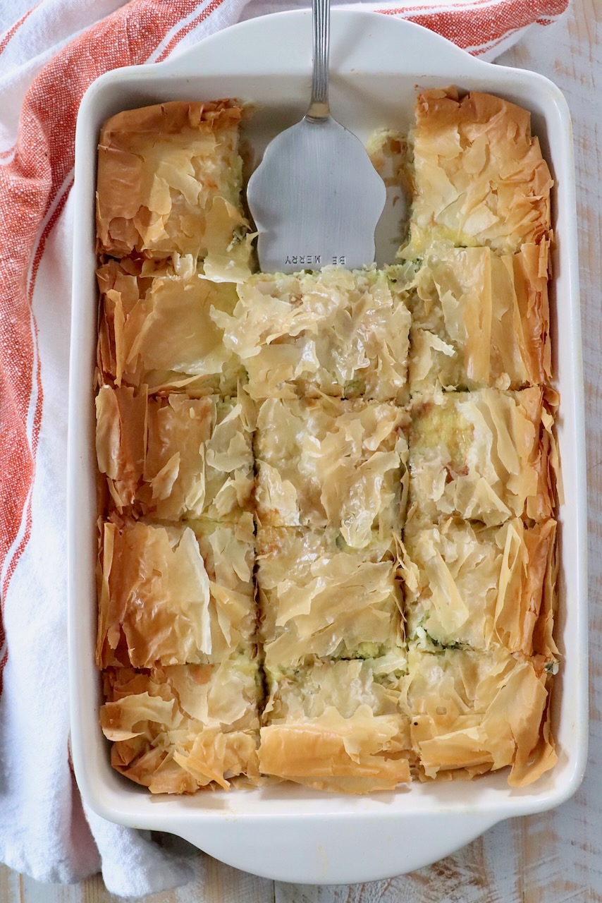 baked zucchini pie with phyllo crust in baking dish with silver pie server