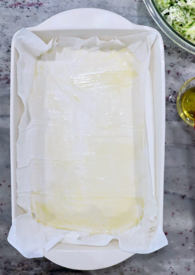 phyllo dough in baking dish brushed with olive oil