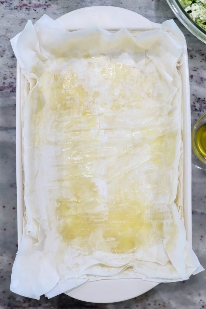 sheets of phyllo dough layered on top of each other in baking dish