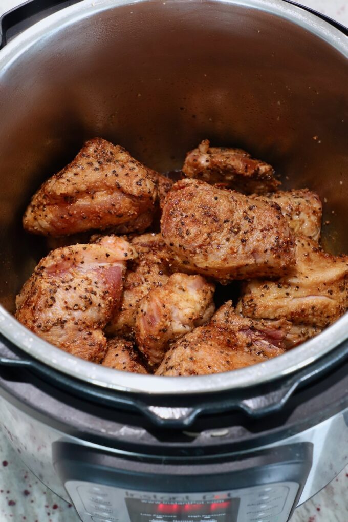 large pieces of seared, seasoned pork in Instant Pot