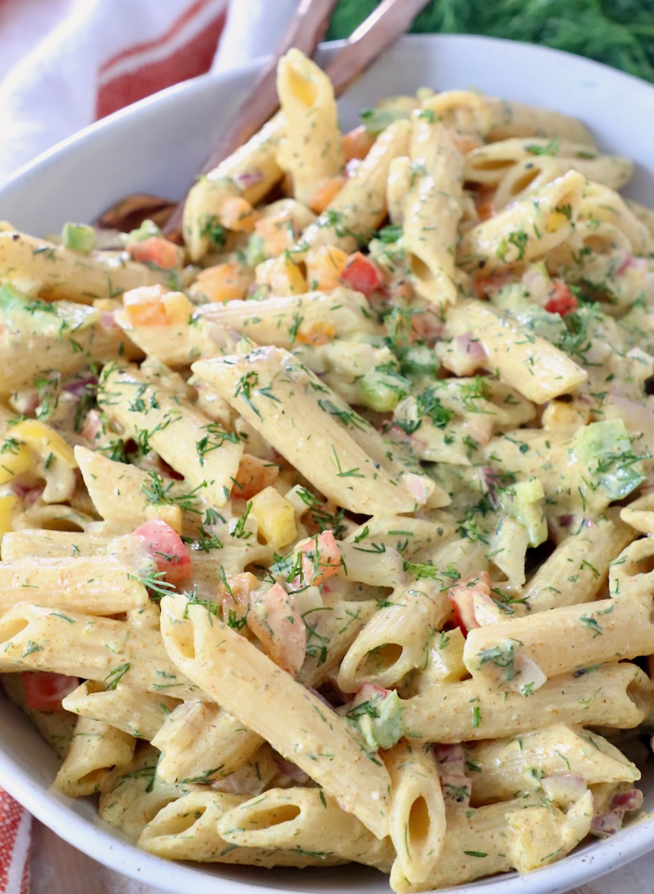 pasta salad tossed with creamy dressing in large bowl