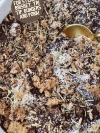 ground coffee mixed with brown sugar and dried herbs in bowl with spoon