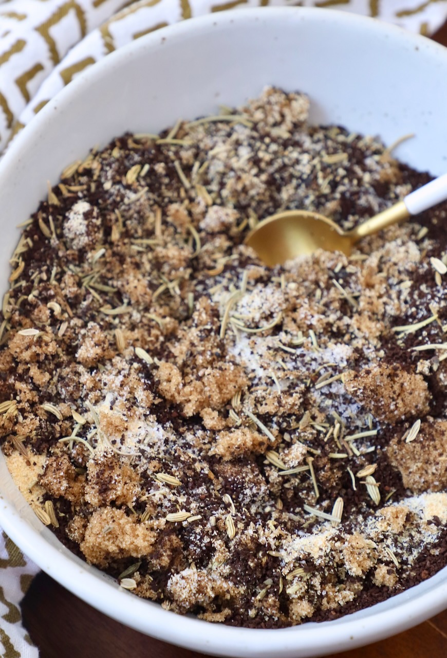 ground coffee mixed with brown sugar and dried herbs in bowl with spoon