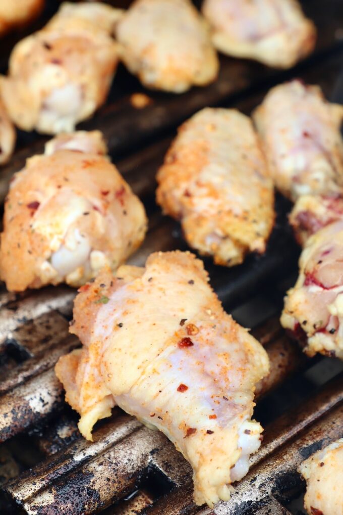 raw seasoned chicken wings on grill