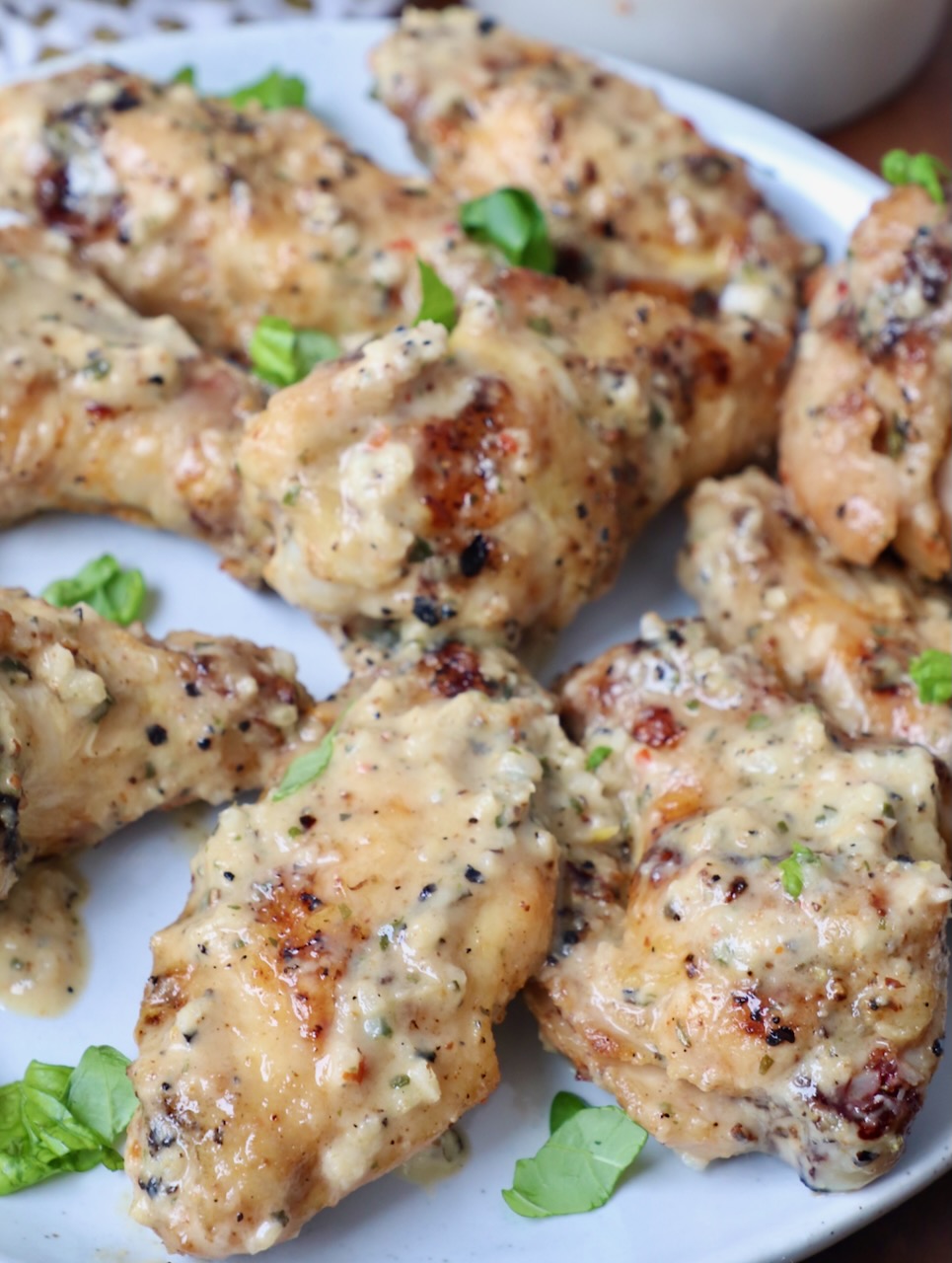 grilled chicken wings tossed in garlic parmesan sauce on plate
