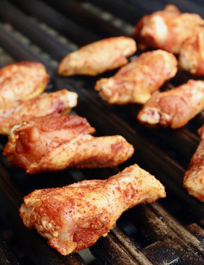 raw seasoned chicken wings on grill