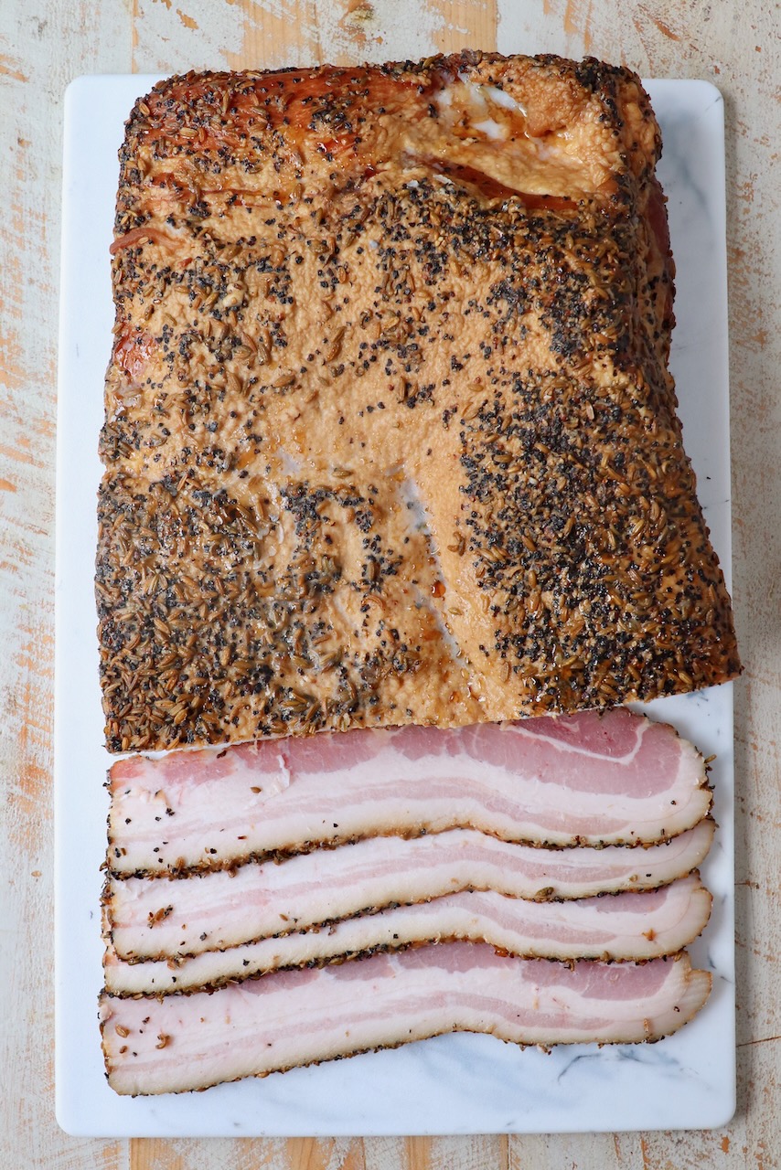 homemade bacon partly sliced on cutting board