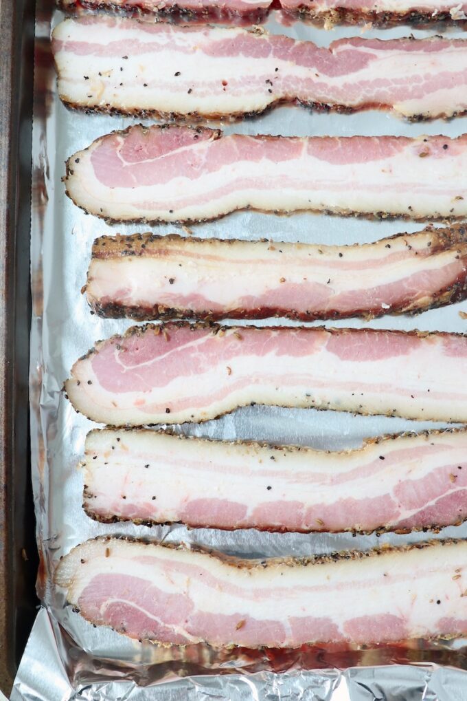 sliced bacon on foil-lined baking sheet