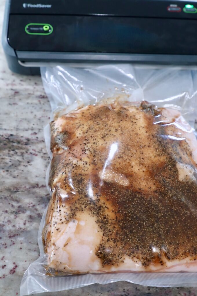 seasoned pork belly in bag in vacuum sealer