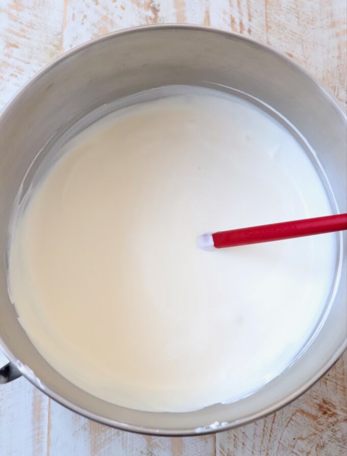 whipped heavy cream in bowl with red spatula