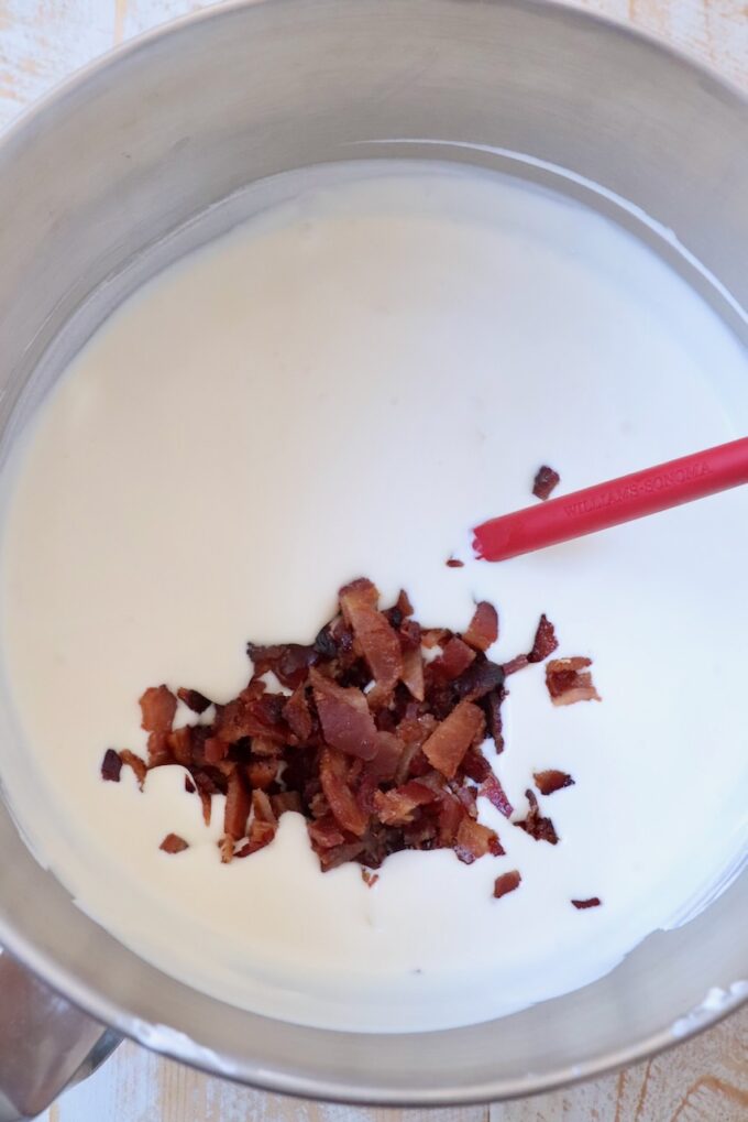 chopped bacon in ice cream base in bowl with red spatrula