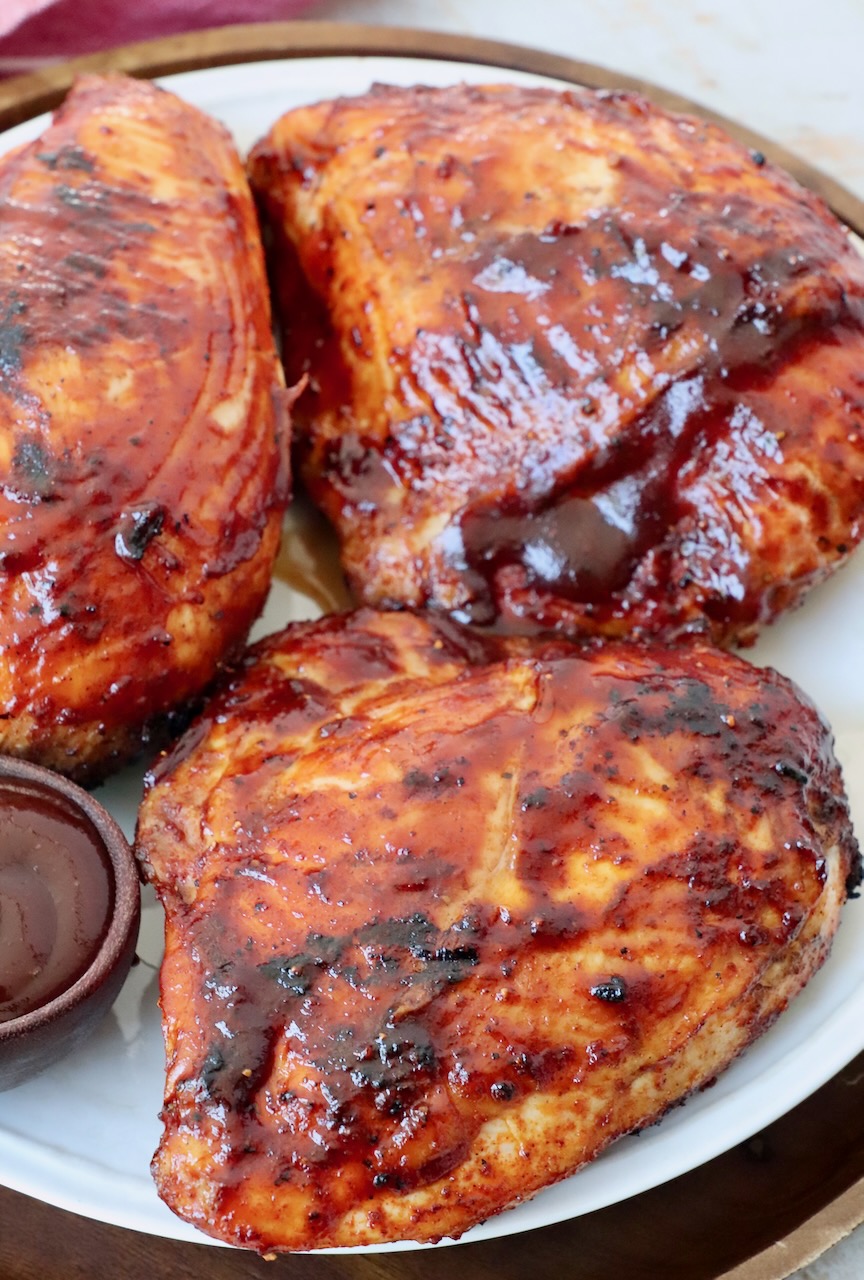 pieces of grilled bone-in bbq chicken breasts on plate