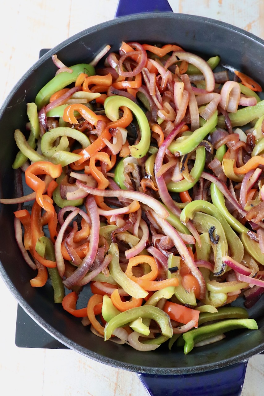 cooked sliced bell peppers and onions in large skillet