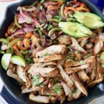 grilled sliced chicken and sliced bell peppers and onions in large skillet