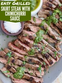 sliced grilled skirt steak on plate topped with chimichurri sauce