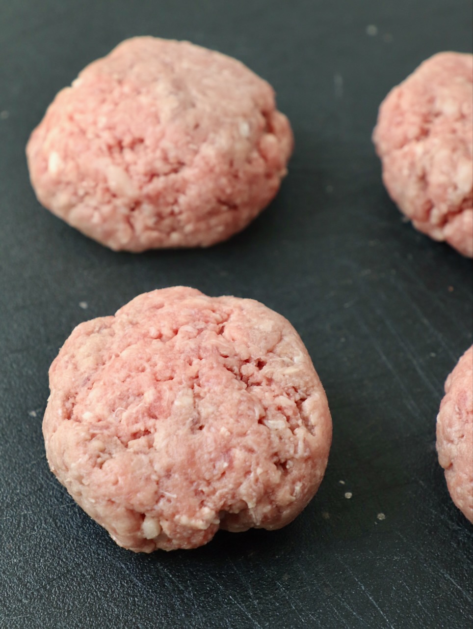 balls of ground beef on cutting board