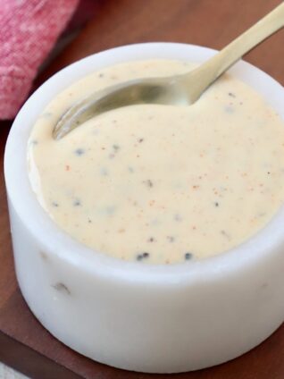 white bbq sauce in small bowl with spoon