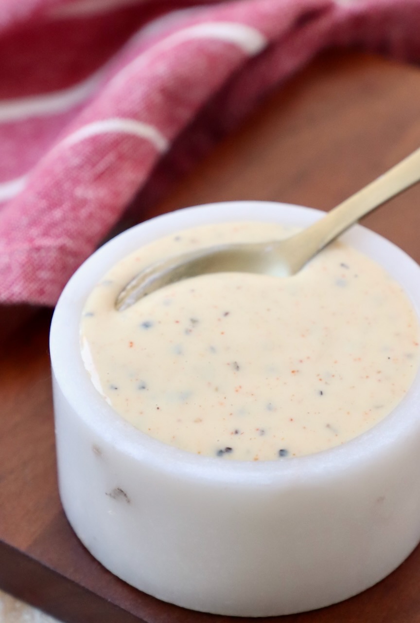 white bbq sauce in small white bowl with spoon