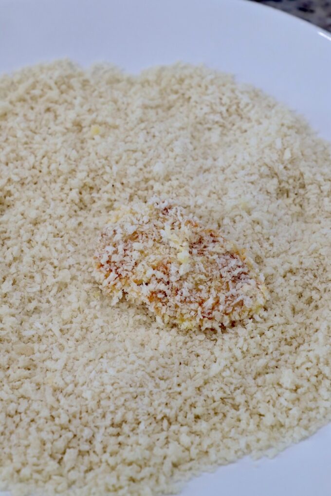 piece of chicken covered in breadcrumbs in bowl