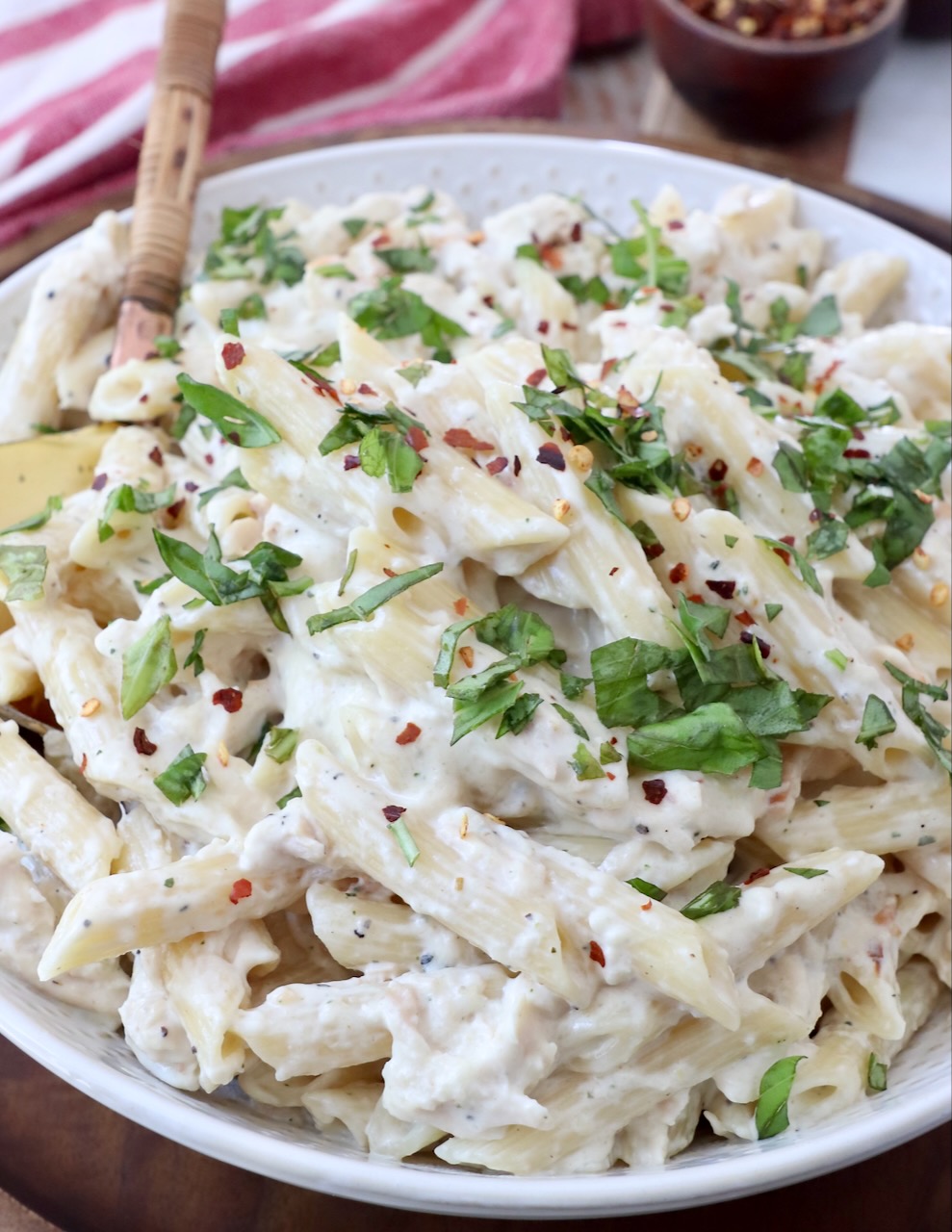 creamy chicken pasta in bowl with serving spoon
