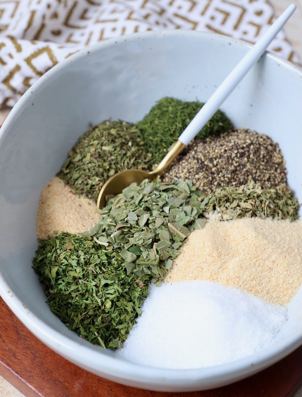 dried herbs and spices separated in bowl with small spoon